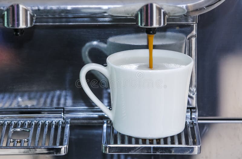 Closeup of Espresso Pouring from Coffee Machine To Make Latte Stock