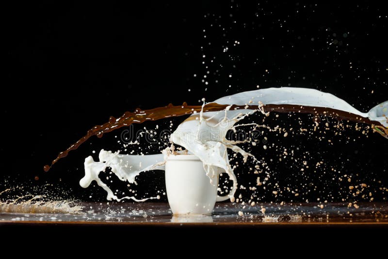 Coffee and milk pouring in a cup stock photo Coffee and milk pouring in a cup stock photo