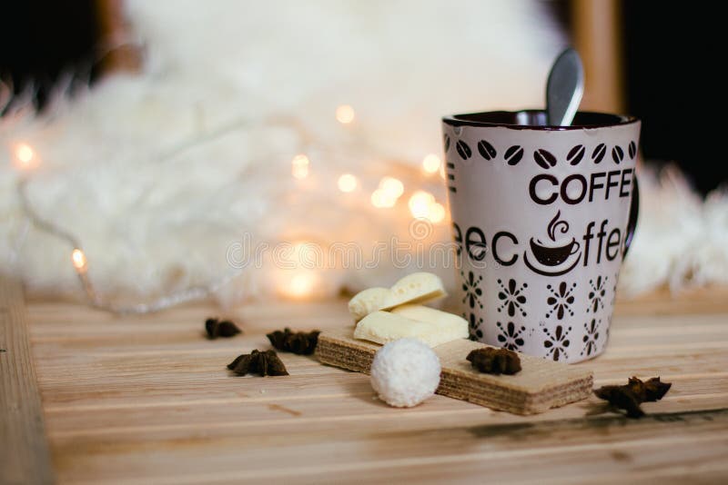 A Coffee Mug with on the Christmas Lights Background on the Wooden