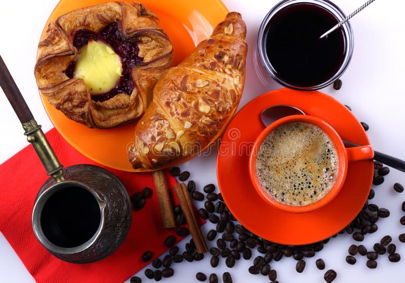 Coffee mug, with a croissant, cheesecake and jam.