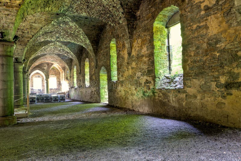 The remains of the ground floor with vaults of the dwelling on the site of the ruined cistercian abbey of Villers la Ville, Belgium. Sun light coming through the frames of the windows projected on the floor of the ruins, which gives the picture a romanesque feeling. The remains of the ground floor with vaults of the dwelling on the site of the ruined cistercian abbey of Villers la Ville, Belgium. Sun light coming through the frames of the windows projected on the floor of the ruins, which gives the picture a romanesque feeling.