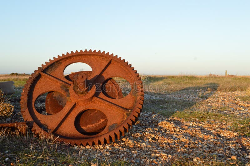 A rusty old cog lies abandoned in barren wasteland, resting now after being turned and cranked in its heyday.