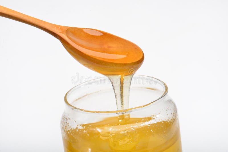 Cognez avec du miel et la cuillère en bois d'isolement sur le fond blanc photos stock Cognez avec du miel et la cuillère en bois d'isolement sur le fond blanc photos stock