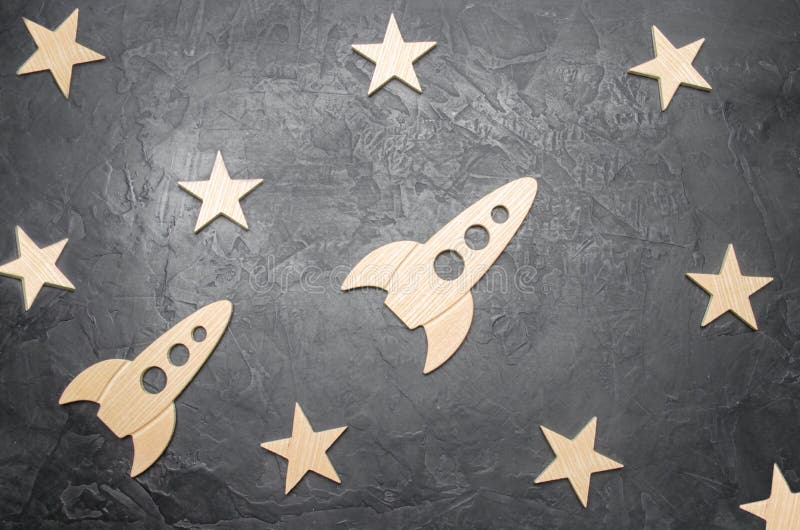 Cohete y estrellas de madera de espacio en un fondo oscuro El concepto de viajes espaciales, el estudio de planetas y estrellas E imagenes de archivo Cohete y estrellas de madera de espacio en un fondo oscuro El concepto de viajes espaciales, el estudio de planetas y estrellas E imagenes de archivo