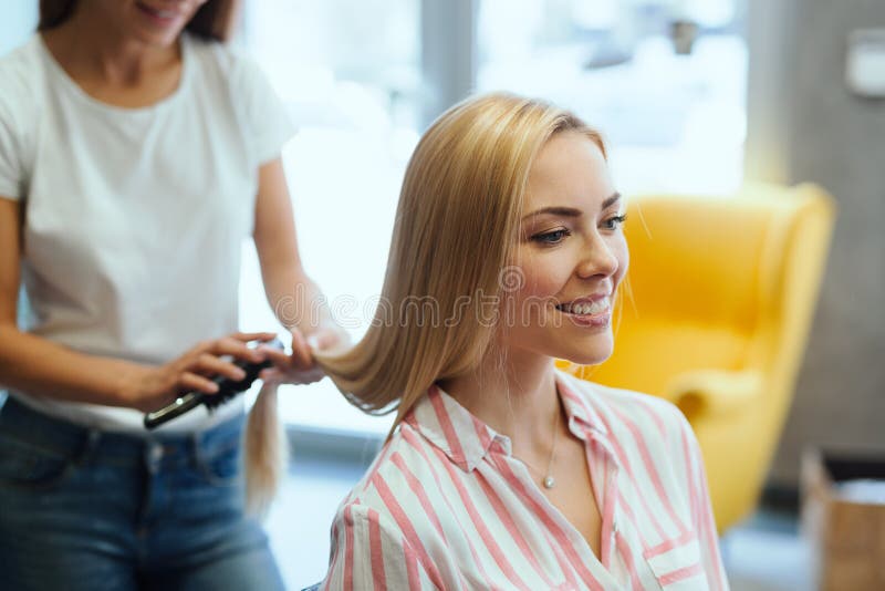 Coiffeur faisant la coupe de cheveux pour des femmes dans le salon de coiffure photo libre de droits Coiffeur faisant la coupe de cheveux pour des femmes dans le salon de coiffure photo libre de droits