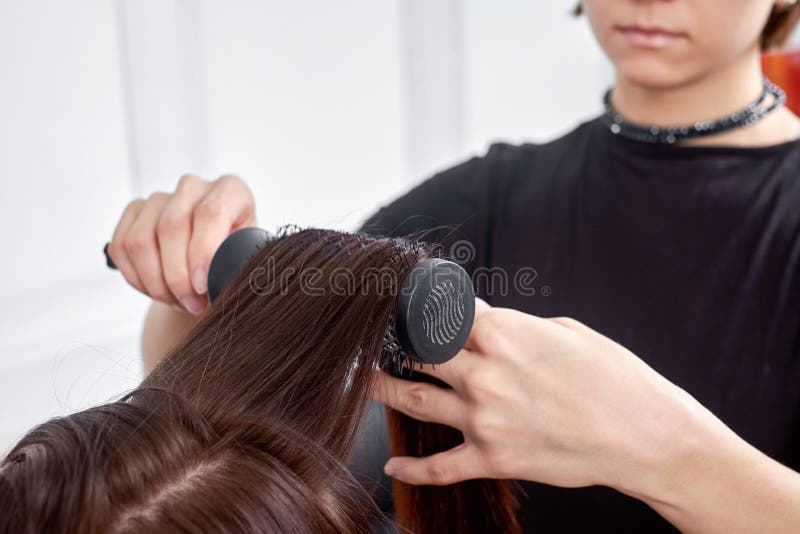 Coiffeur faisant la nouvelle coupe de cheveux à la femme de brune dans le salon photo stock Coiffeur faisant la nouvelle coupe de cheveux à la femme de brune dans le salon photo stock