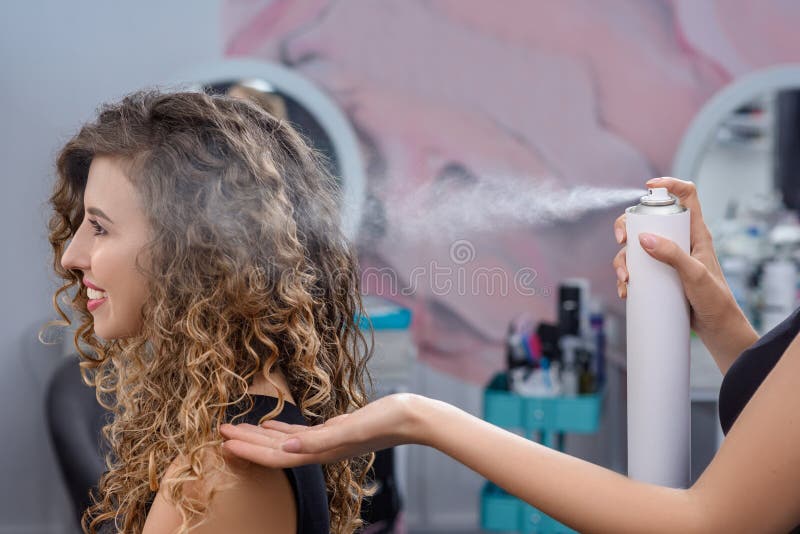 Coiffure de fixation de styliste avec la laque dans le salon de beauté photos stock Coiffure de fixation de styliste avec la laque dans le salon de beauté photos stock