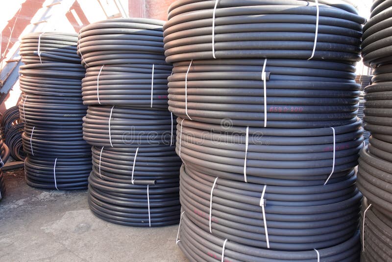 Coiled Black Plastic Pipes Stored Outdoors. Stock Image Image of