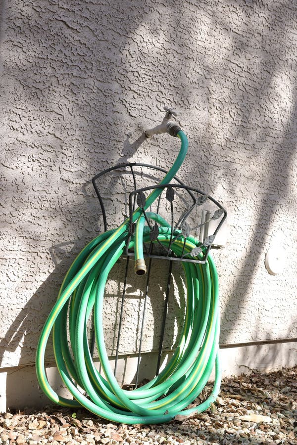 Coiled Green Garden Hose stock image. Image of wall 268577821