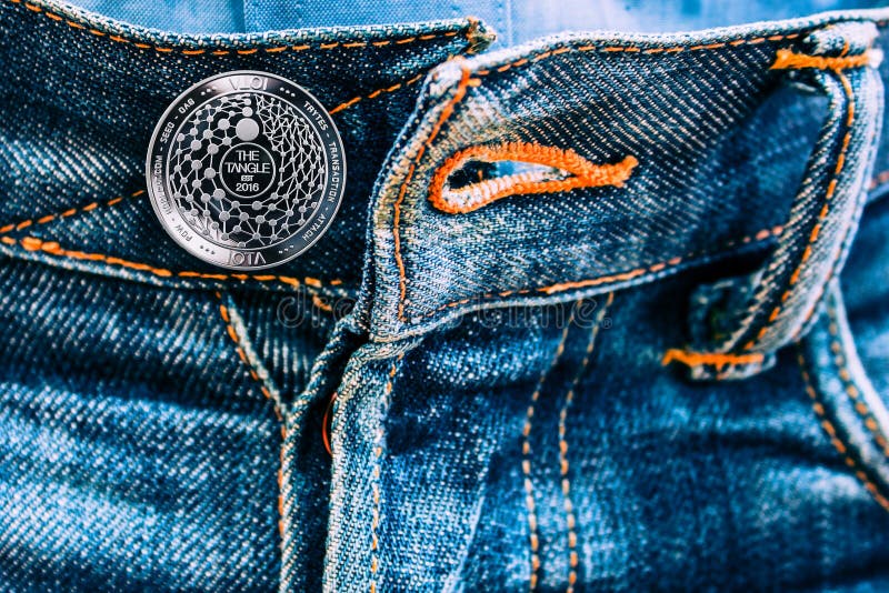 Miota coin instead of buttons on jeans. stock photo Miota coin instead of buttons on jeans. stock photo