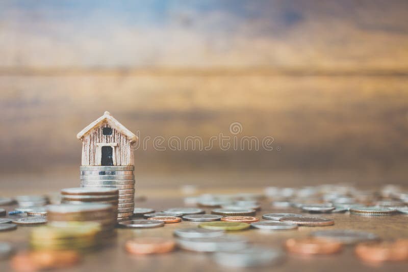Coin money and house model on wooden background stock photos Coin money and house model on wooden background stock photos