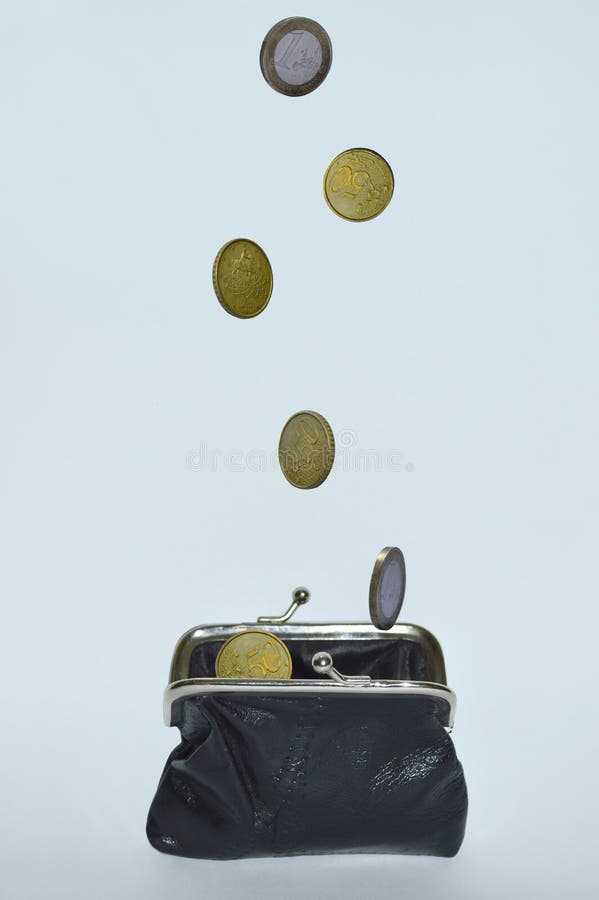 Coins falling in a black leather purse on a white background