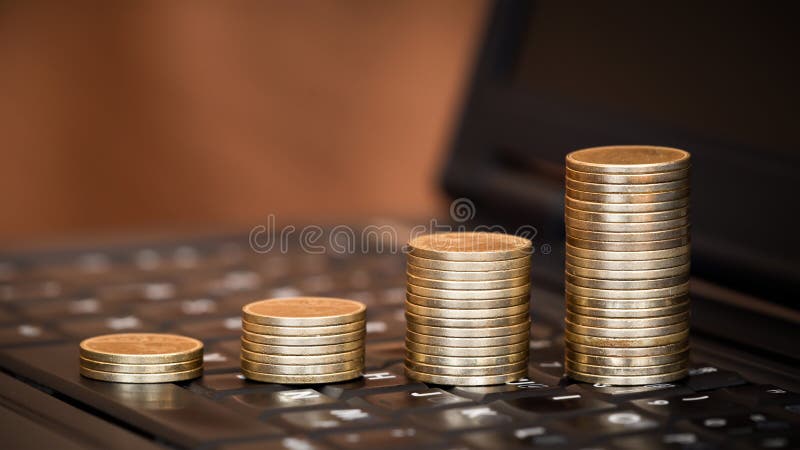 Coins on a laptop keyboard, money savings banner