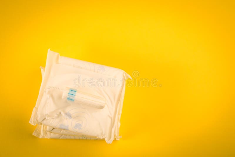 Cojines sanitarios y tapón en un fondo amarillo Producto de higiene imagen de archivo Cojines sanitarios y tapón en un fondo amarillo Producto de higiene imagen de archivo