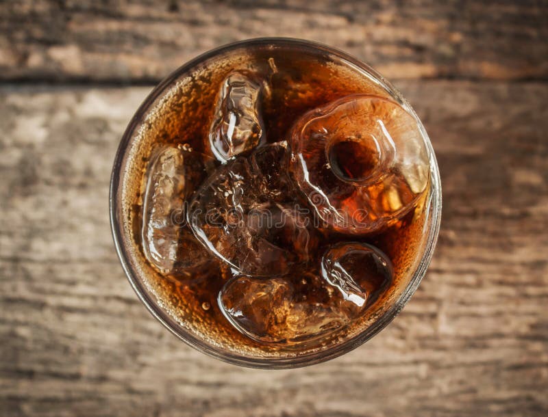 Cola in glass with ice from top view.