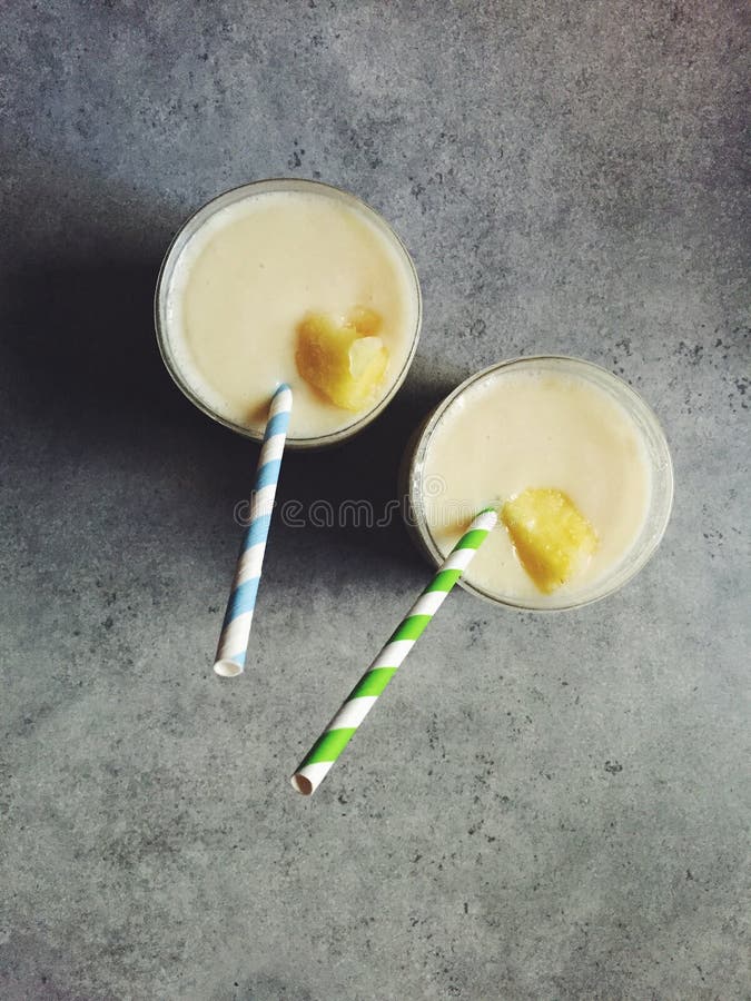 Colada fait maison de piña en deux verres avec des pailles de papier rayé photographie stock libre de droits Colada fait maison de piña en deux verres avec des pailles de papier rayé photographie stock libre de droits