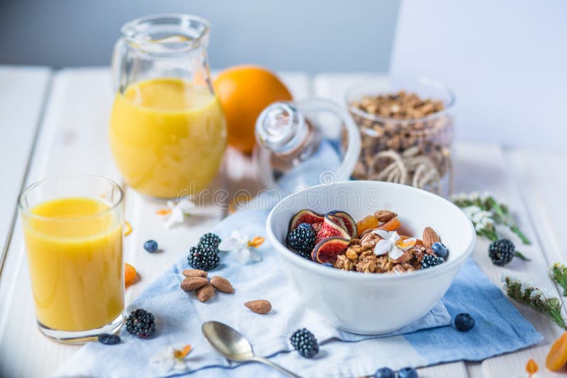 Colazione salutare con porridge di farina d'avena con more fresco, fichi e frutta a guscio Succhi e arance immagini stock libere da diritti Colazione salutare con porridge di farina d'avena con more fresco, fichi e frutta a guscio Succhi e arance immagini stock libere da diritti