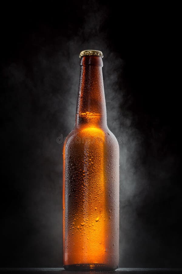 Cold beer bottle with drops on black