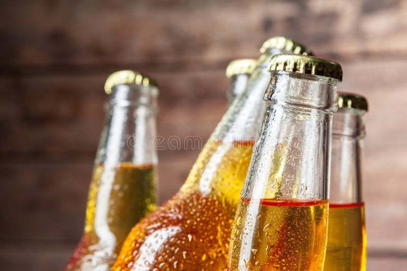 Cold bottles of beer in the bucket on the wooden background