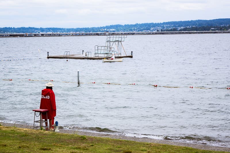 A cold female lifeguard on the beach at Madison Park, Seattle