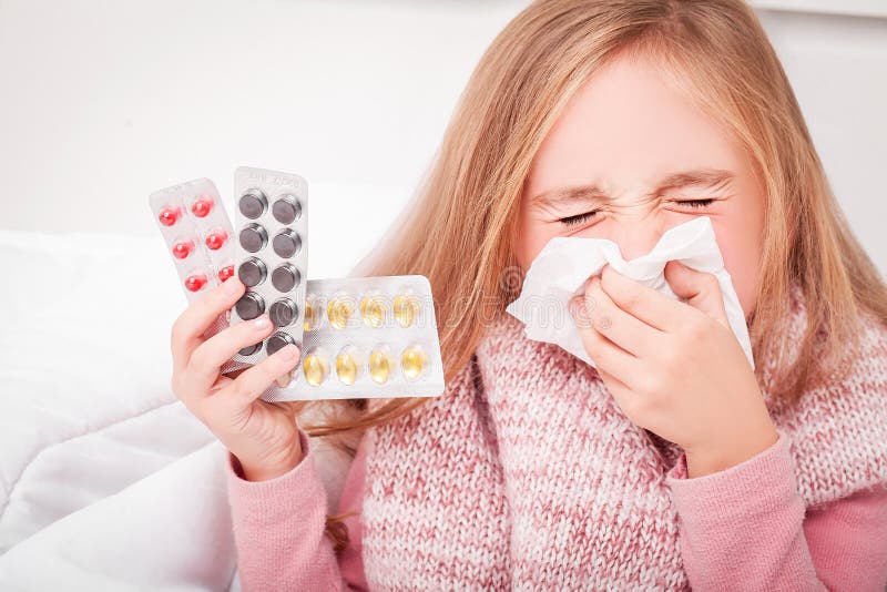 Cold and flu. A girl with pills in her hands royalty free stock images