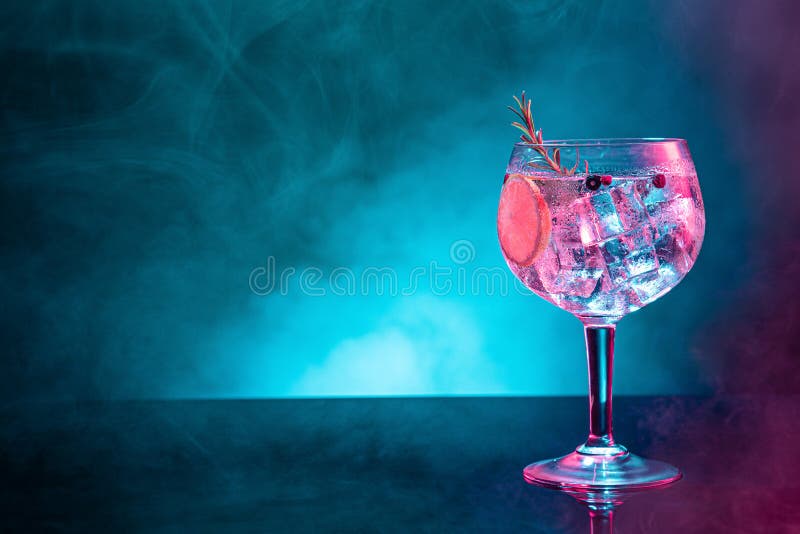 Cold Gin Tonic Under Pink and Blue Light Illumination on Smoky Background with Copy Space Stock