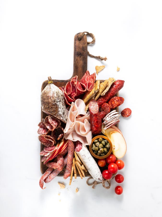 Cold meat plate, charcuterie on white background with copy space. Traditional Spanish tapas selection - chorizo, salchichon, jamon