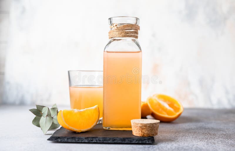 Cold and Refreshing Fresh Orange Juice in Glass and Bottle with Fresh