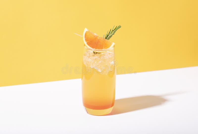 Cold and refreshing orange punch cocktail with orange slice on yellow background. summer drink