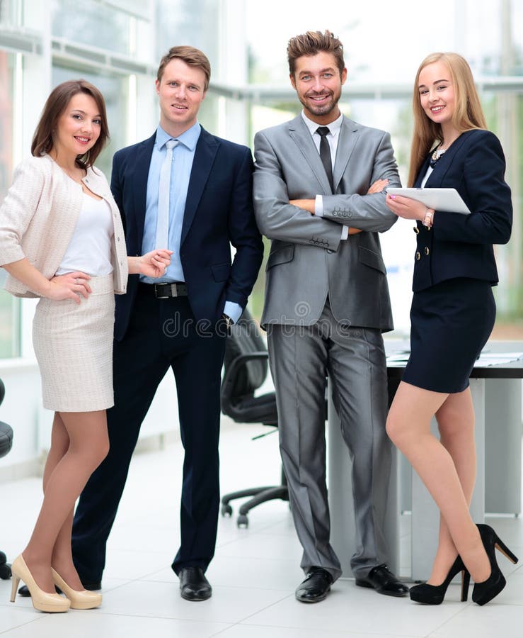 Colegas de trabalho elegantes que olham a câmera durante a reunião no escritório imagens de stock royalty free Colegas de trabalho elegantes que olham a câmera durante a reunião no escritório imagens de stock royalty free