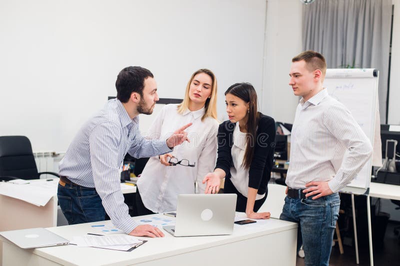 Colegas de trabalho novos do grupo que fazem grandes decisões empresariais Escritório moderno criativo de Team Discussion Corpora imagens de stock royalty free Colegas de trabalho novos do grupo que fazem grandes decisões empresariais Escritório moderno criativo de Team Discussion Corpora imagens de stock royalty free
