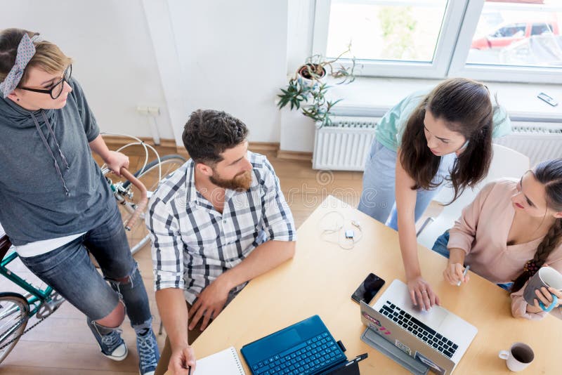 Colegas de trabalho novos que cooperam ao trabalhar como freelancers imagens de stock royalty free Colegas de trabalho novos que cooperam ao trabalhar como freelancers imagens de stock royalty free