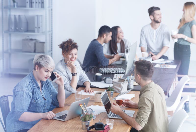 Colegas de trabalho que apreciam o tempo no trabalho imagem de stock Colegas de trabalho que apreciam o tempo no trabalho imagem de stock