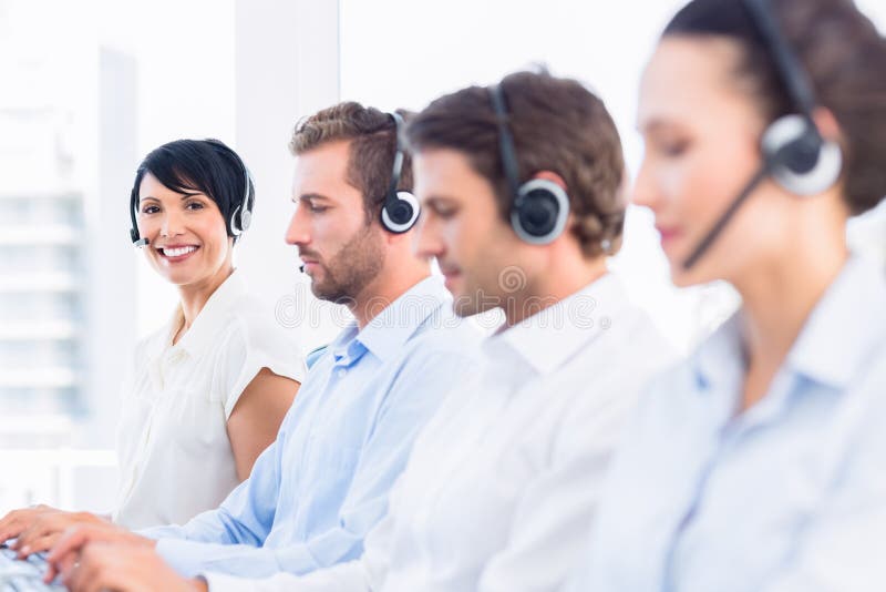 Colegi de afaceri cu căști în rând stock images