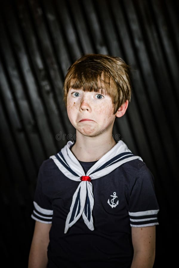 Colegial que presenta en traje del marinero con emociones imagen de archivo libre de regalías Colegial que presenta en traje del marinero con emociones imagen de archivo libre de regalías