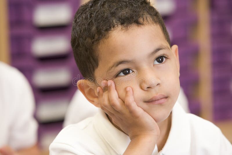 Colegial que se sienta en clase primaria fotografía de archivo Colegial que se sienta en clase primaria fotografía de archivo