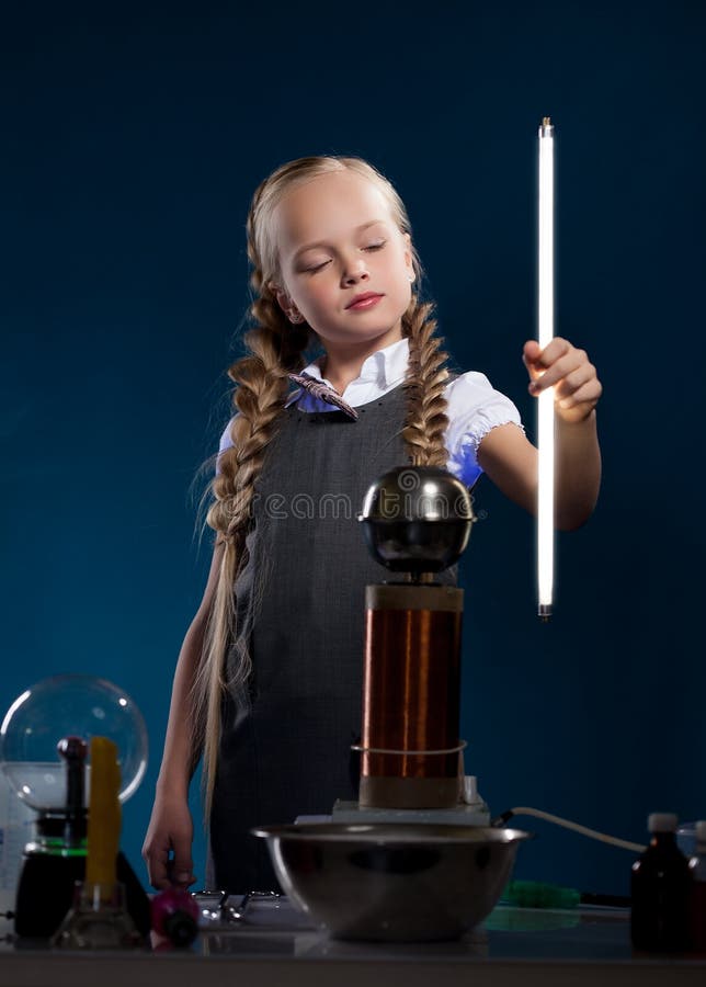 Colegiala amontonada que presenta con la lámpara que brilla intensamente imagenes de archivo