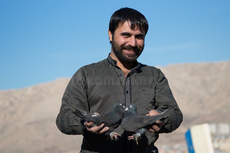 Colecionador de pombos sorrindo e segurando pombos pretos imagens de stock