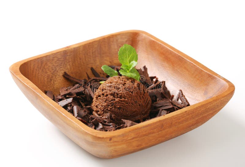 Scoop of ice cream and chocolate shavings in wooden bowl. Scoop of ice cream and chocolate shavings in wooden bowl
