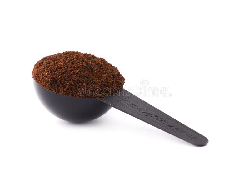 A colher de medição encheu-se com o café sobre o fundo branco isolado fotografia de stock A colher de medição encheu-se com o café sobre o fundo branco isolado fotografia de stock
