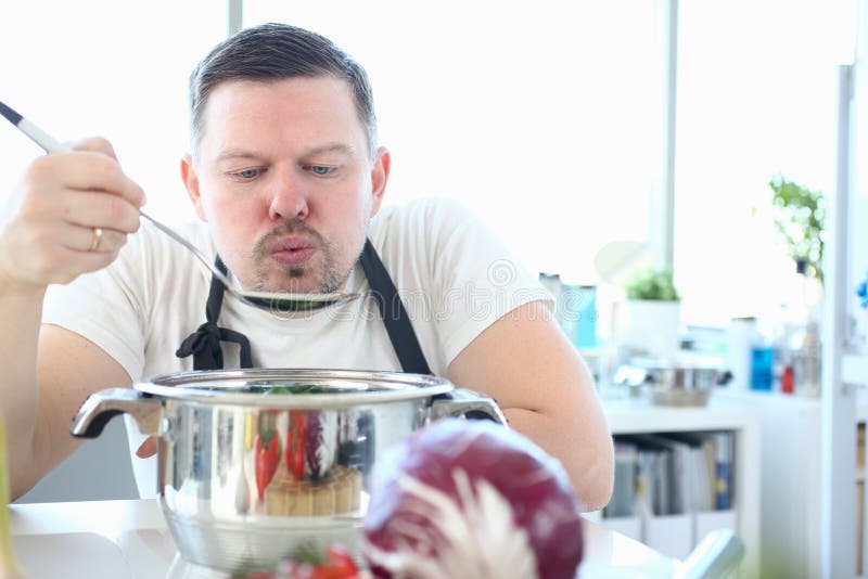 Cara Soprando Numa Colher Para Provar Comida Cozida Foto de Stock - Imagem  de alimento, cozinheiro: 270887440