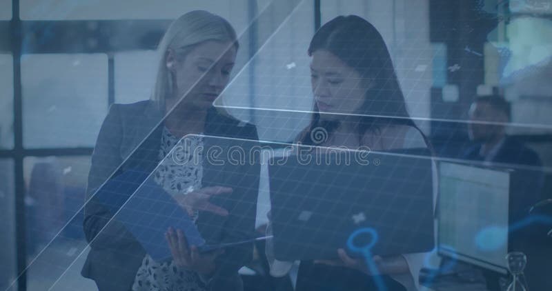 Collaborating on laptops, two women using digital animation data in office stock illustration