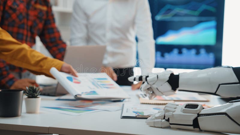 A captivating scene of humans collaborating with a robot in a modern office, showcasing charts and high-tech devices that illustrate innovative teamwork and data analysis. Noogenesis. Robots working futuristic office stock images, royalty-free photos and pictures