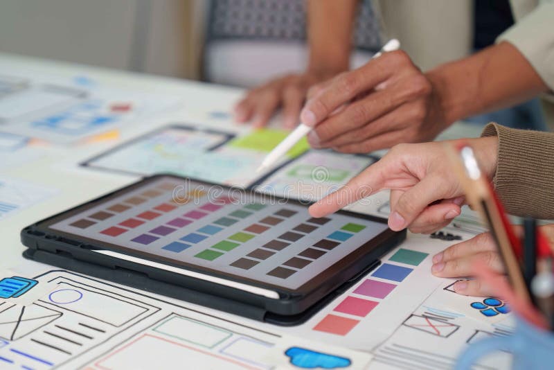 Collaborative Design. Team brainstorming on digital interface mockups and color palettes. royalty free stock image