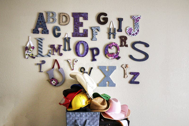 Collage of alphabet letters on the wall of a playroom. Collage of different style alphabet letters on the wall of a home playroom with fun dress-up hats stock photography Collage of alphabet letters on the wall of a playroom. Collage of different style alphabet letters on the wall of a home playroom with fun dress-up hats stock photography