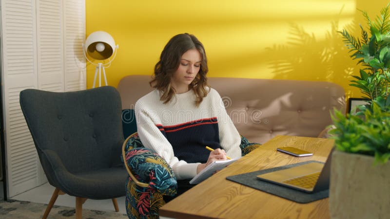 Collage étudiant faire les devoirs à la maison. femme réfléchie faisant des notes banque de vidéos