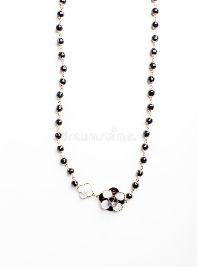 Collana con il fiore e le perle nere isolati vicino su immagine stock libera da diritti Collana con il fiore e le perle nere isolati vicino su immagine stock libera da diritti