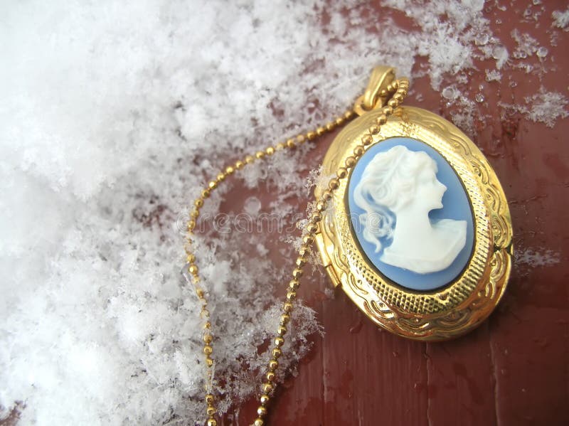 A cameo locket with snow surrounding it. A cameo locket with snow surrounding it