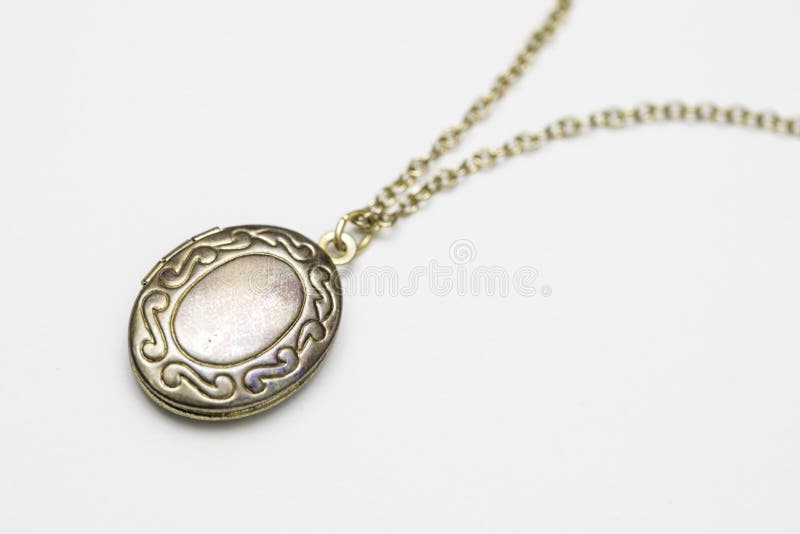 Gold pendant locket necklace on a white background shot up close. Gold pendant locket necklace on a white background shot up close