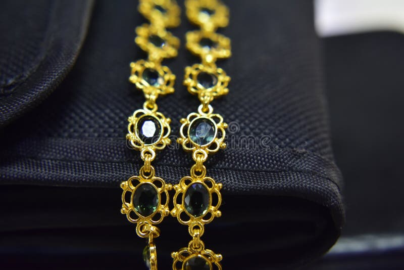 Collana dell'oro decorata con le pietre verde smeraldo genuine fotografie stock libere da diritti